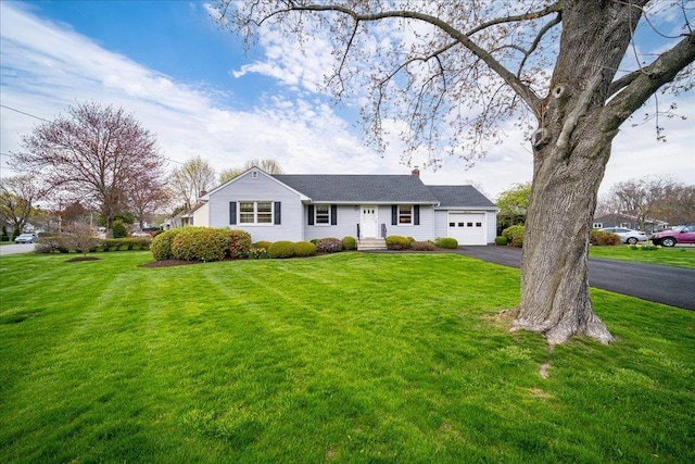 ranch-style home featuring an attached garage, driveway, and a front yard
