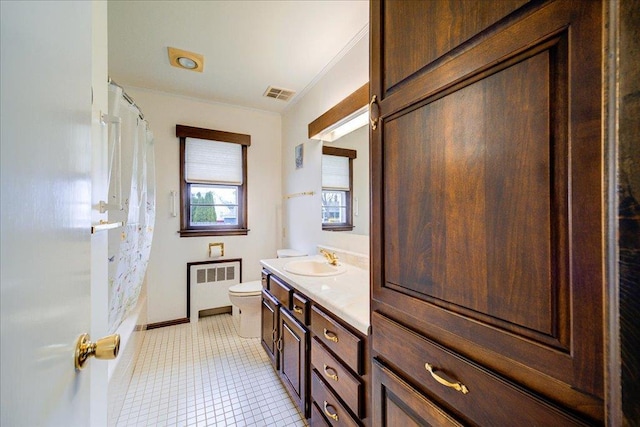bathroom featuring visible vents, vanity, baseboards, toilet, and radiator heating unit