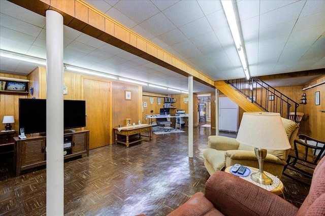 living room with wood walls, stairs, and gas water heater