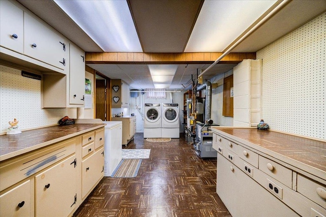 clothes washing area with washing machine and dryer, cabinet space, and a heating unit
