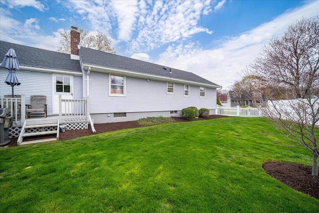 back of house featuring a yard, fence, a chimney, and a wooden deck