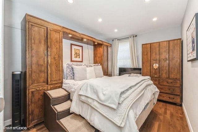bedroom with wood finished floors, recessed lighting, and baseboards