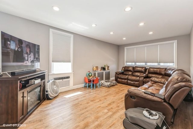 living room with light wood-type flooring, recessed lighting, and baseboards