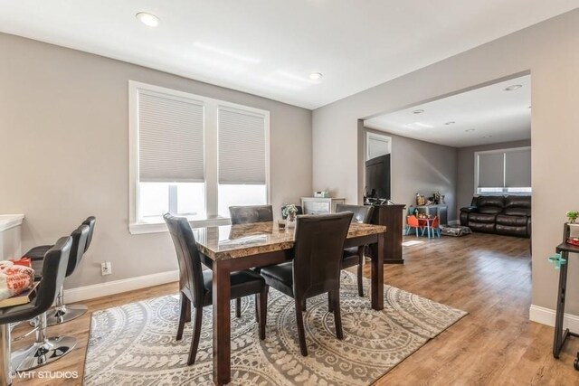 dining room featuring baseboards, recessed lighting, and light wood-style floors