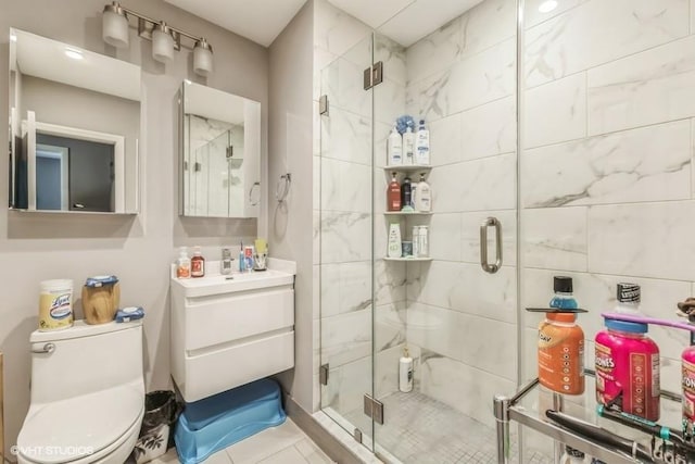 bathroom with tile patterned floors, a shower stall, toilet, and vanity