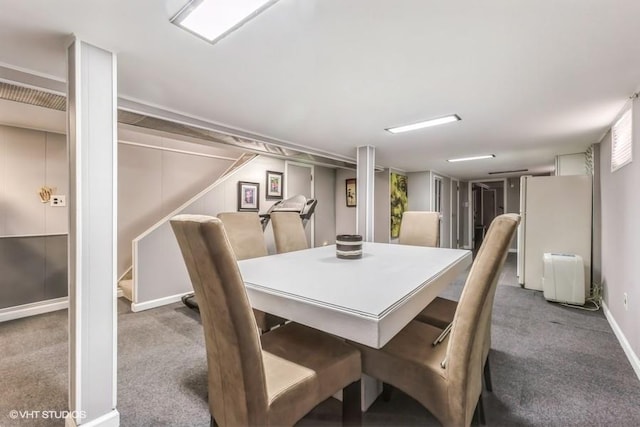 carpeted dining room featuring baseboards and stairs