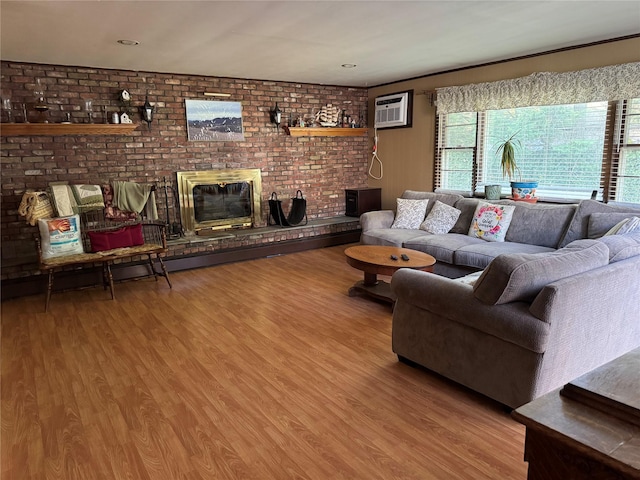 living room with a fireplace, brick wall, a wall mounted air conditioner, and wood finished floors
