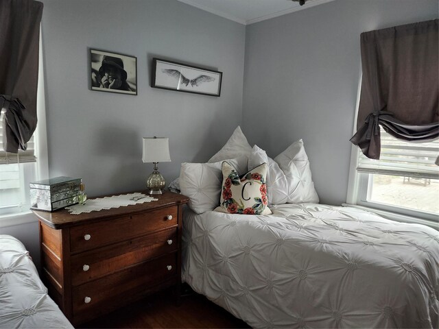 bedroom with crown molding and dark wood-type flooring