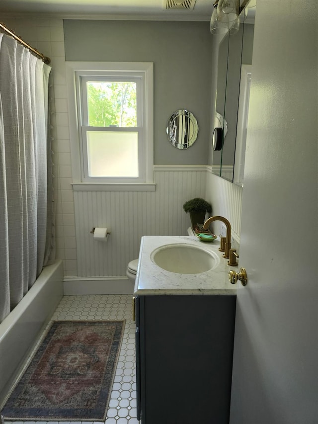 2575 Oaklawn Ave, Southold, NY 11971 - bathroom with vanity, a wainscoted wall, toilet, shower / bath combo, and tile patterned floors