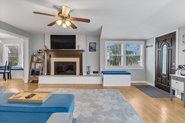 living area with a healthy amount of sunlight, baseboards, a ceiling fan, and wood finished floors