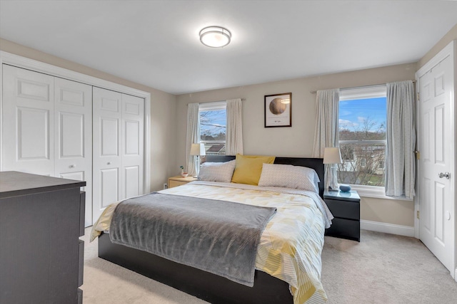 bedroom featuring baseboards, a closet, and light carpet