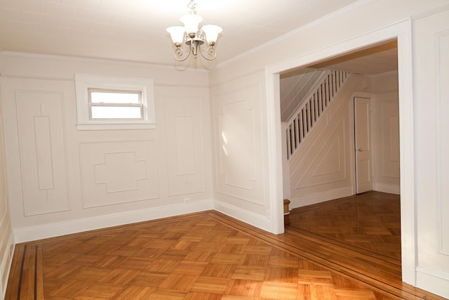 empty room featuring ornamental molding, a notable chandelier, stairs, and a decorative wall