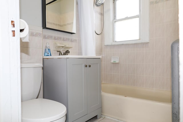 bathroom with vanity, toilet, and tile walls
