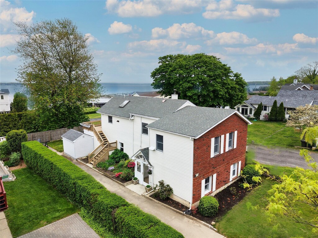 1250 2nd St, New Suffolk, NY 11956 - view of property exterior with a water view, stairway, a chimney, roof with shingles, and brick siding