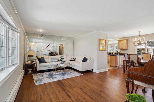 living area with crown molding, a baseboard radiator, dark wood-style floors, a notable chandelier, and stairs