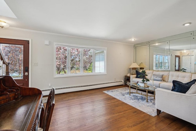 living area featuring crown molding, a baseboard heating unit, and wood finished floors
