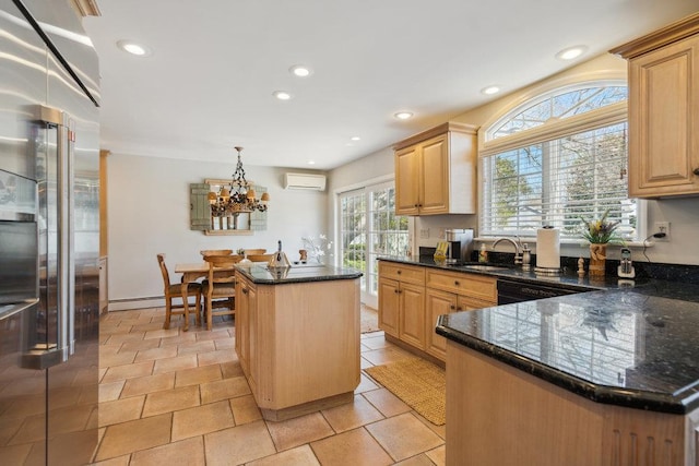 kitchen with a wall unit AC, a center island, high end refrigerator, a sink, and an inviting chandelier