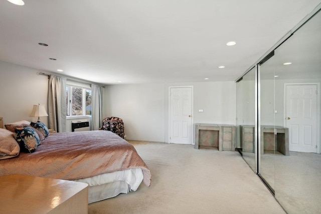 bedroom featuring recessed lighting, a closet, light carpet, and a fireplace