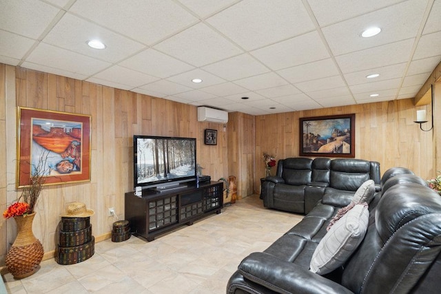 living room with wood walls, a paneled ceiling, and a wall mounted air conditioner