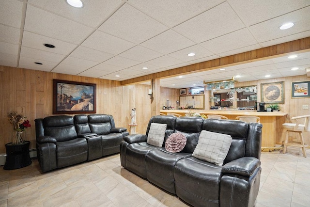 living room featuring recessed lighting, wood walls, bar, and a paneled ceiling