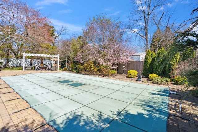 view of swimming pool with fence, a pergola, a covered pool, and a patio