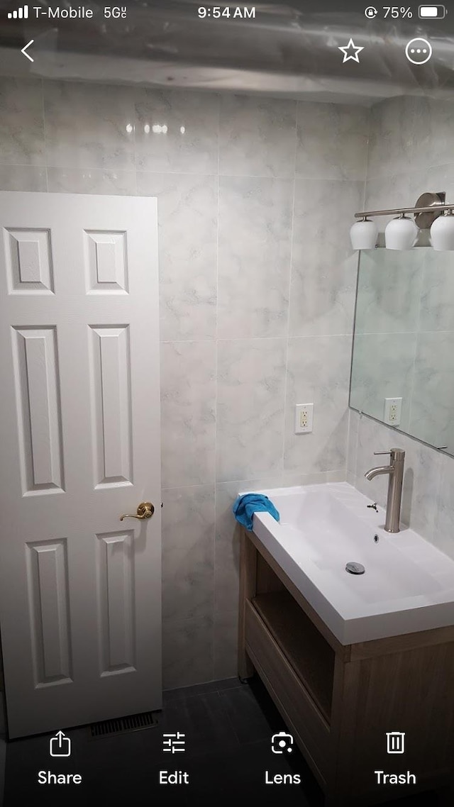 bathroom featuring tile walls and vanity