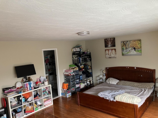 bedroom featuring a textured ceiling and wood finished floors