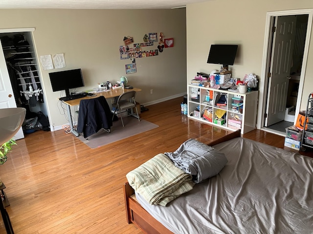 bedroom with baseboards and wood finished floors