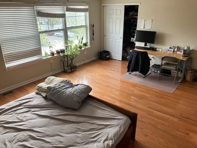 bedroom featuring visible vents, baseboards, and wood finished floors