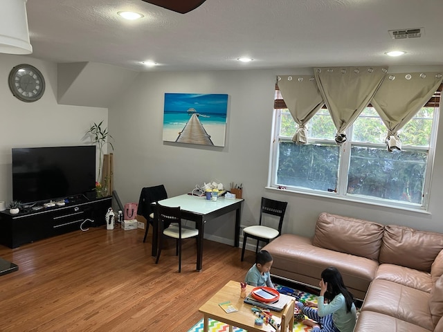 living room with recessed lighting, visible vents, a healthy amount of sunlight, and light wood-style floors