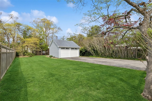 view of yard with a garage, fence, and an outdoor structure