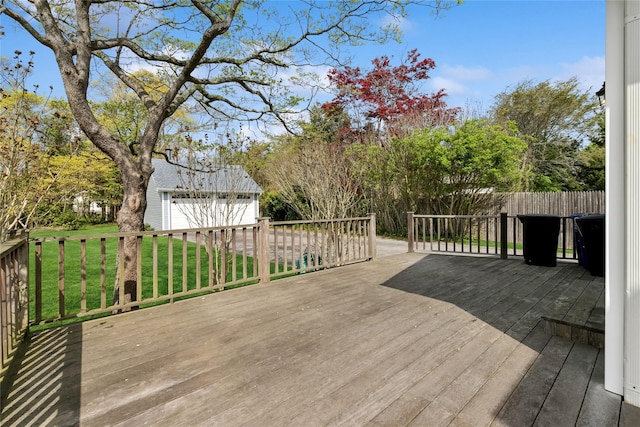 deck featuring a garage, an outdoor structure, and a yard