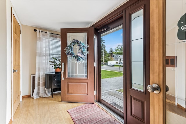 foyer with baseboards and light wood-style flooring
