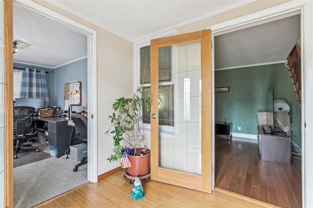 interior space featuring baseboards, ornamental molding, and wood finished floors