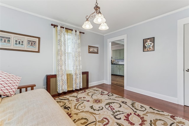 bedroom featuring baseboards, crown molding, and wood finished floors