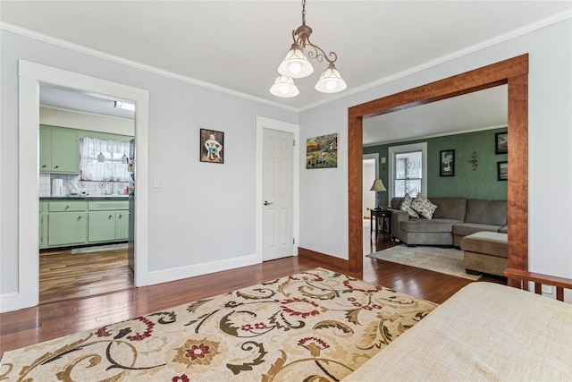 interior space featuring crown molding, baseboards, plenty of natural light, and hardwood / wood-style flooring
