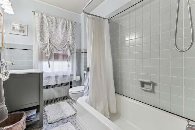 bathroom featuring shower / bath combo with shower curtain, vanity, toilet, tile walls, and a wainscoted wall