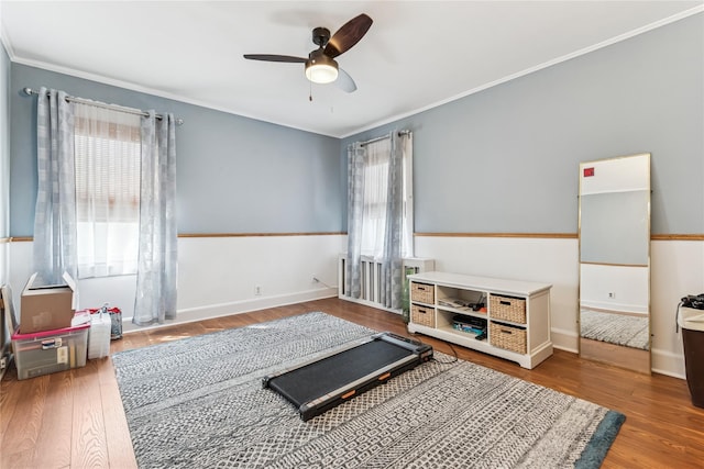 exercise room with a ceiling fan, ornamental molding, a wealth of natural light, and wood finished floors