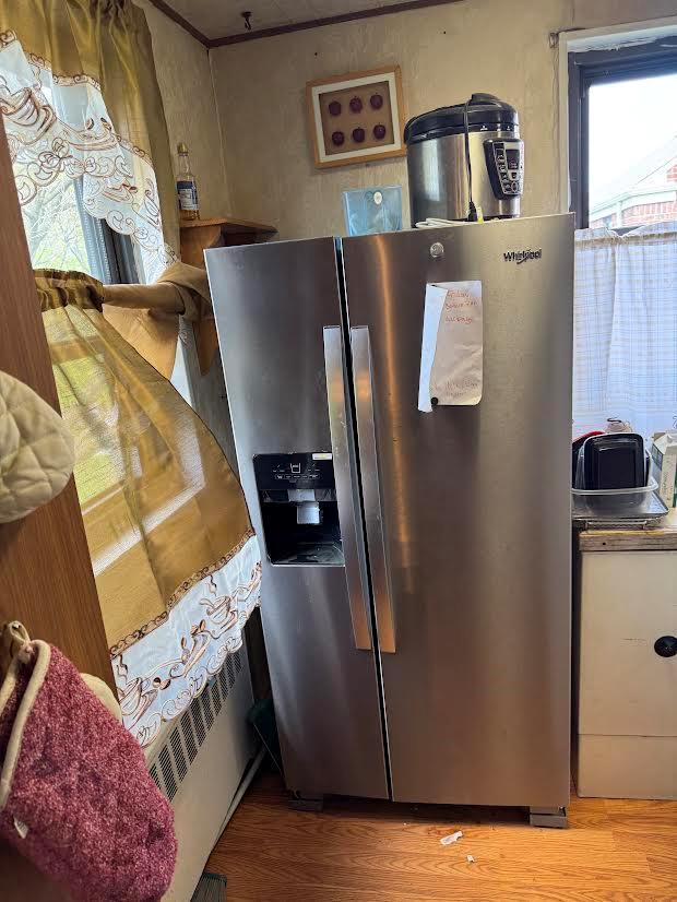 interior space with stainless steel refrigerator with ice dispenser and wood finished floors