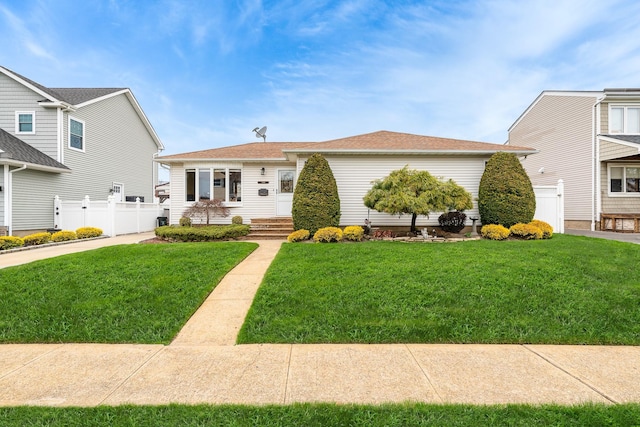 view of front of home with fence and a front lawn