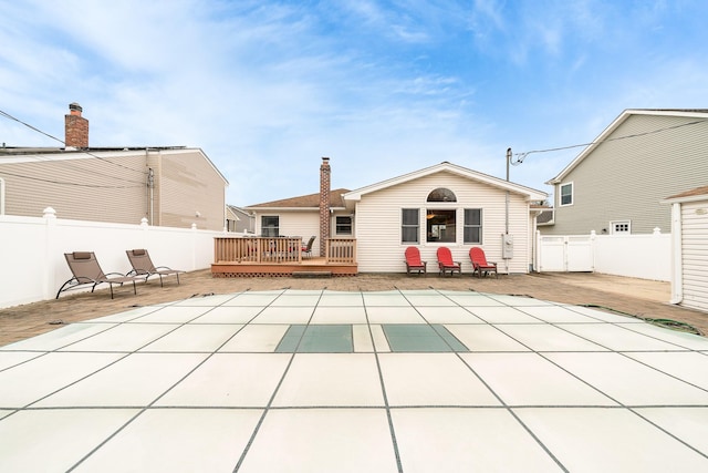 back of property featuring a patio area, a wooden deck, and fence