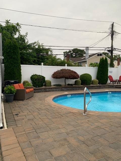 view of swimming pool with a fenced backyard, a fenced in pool, and a patio area