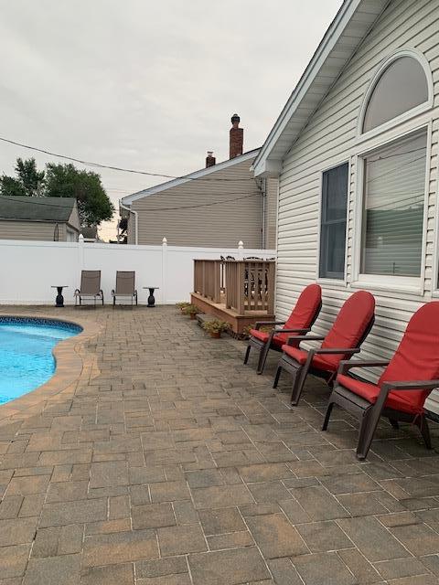 exterior space with a fenced in pool, a wooden deck, and a fenced backyard