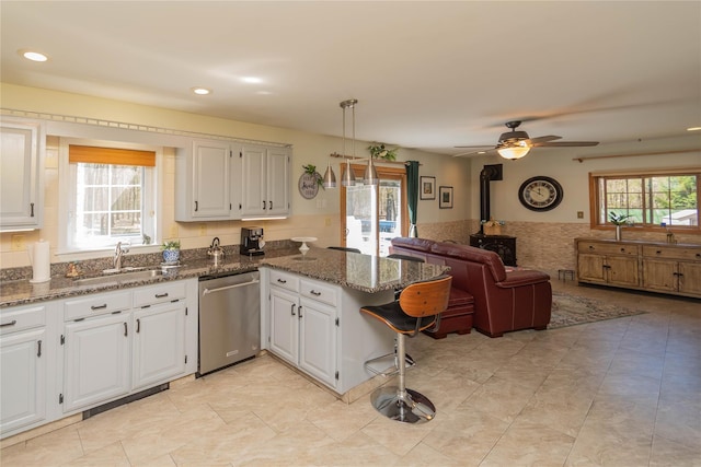 252 Southwoods Dr, Monticello, NY 12701 - kitchen with a sink, a wood stove, dishwasher, a peninsula, and open floor plan