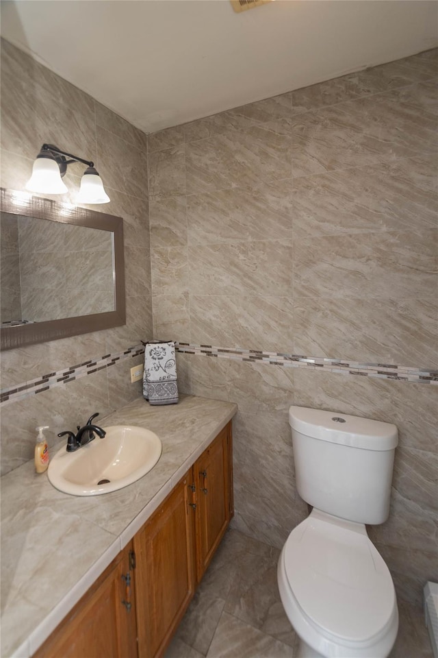 252 Southwoods Dr, Monticello, NY 12701 - half bath featuring vanity, tasteful backsplash, toilet, and tile walls