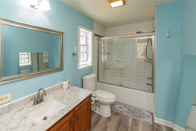 252 Southwoods Dr, Monticello, NY 12701 - full bathroom featuring vanity, bath / shower combo with glass door, toilet, and wood finished floors