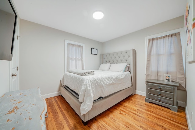 bedroom with baseboards and light wood finished floors