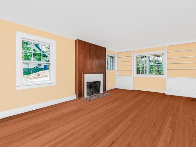 unfurnished living room featuring a large fireplace and wood finished floors