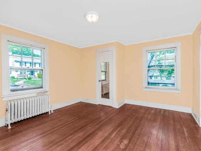 unfurnished room with crown molding, baseboards, wood finished floors, and radiator