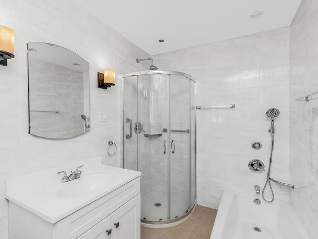 bathroom featuring vanity, a bathing tub, a shower with shower door, and tile patterned flooring